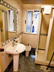 格拉纳达格拉纳达AB膳食公寓的一间带水槽、卫生间和镜子的浴室