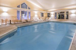 贝尔格莱德贝尔格莱德/博兹曼机场奎因塔套房酒店的一个带椅子和桌子的大型游泳池