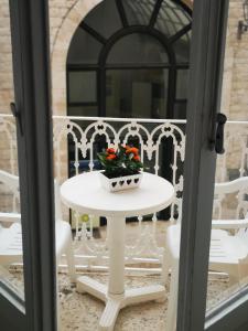 焦维纳佐Il Da Vinci casa vacanze的阳台上的白色花桌