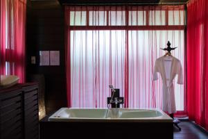 南府利萨西尼水疗度假酒店的浴室设有水槽和红色窗帘