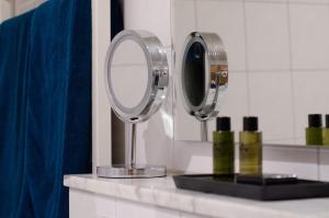 Sassenberg埃姆菲尔德马科斯旅馆的浴室设有两面镜子和蓝色窗帘