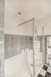 里摩日Contact Hôtel Limoges - HOTEL DES DEUX MOULINS的带淋浴和浴缸的浴室,配有玻璃门