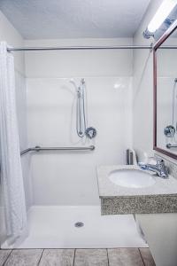 法戈法戈北达科他州立大学蜡烛套房酒店的白色的浴室设有水槽和淋浴。