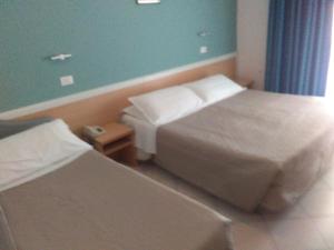 里米尼萨维娜酒店的酒店客房设有两张床和蓝色的墙壁。