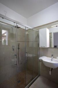 阿尔盖罗Cala Azul Residence B&B的一间带玻璃淋浴和水槽的浴室