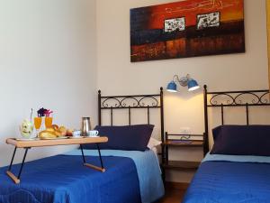 扎费拉纳-埃特内阿Poggiofelice B&B的一间设有两张床的房间和一张带水果的桌子