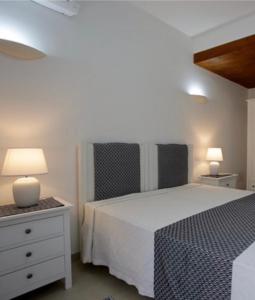 阿尔盖罗Cala Azul Residence B&B的卧室配有白色的床和两盏灯。