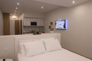 LákonesLakones Deluxe Suites的客厅配有一张床和墙上的电视