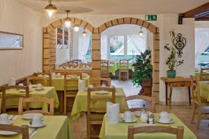 采尔马特埃内克斯安迪卡酒店的一间设有绿色桌椅和拱门的餐厅