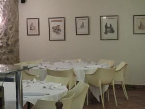 埃斯塔蒂特圣安娜酒店的用餐室配有白色的桌子和白色的椅子