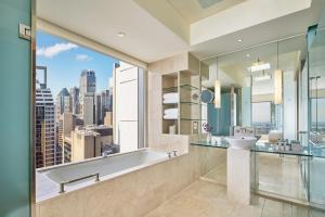 悉尼The Fullerton Hotel Sydney的带浴缸、水槽和窗户的浴室