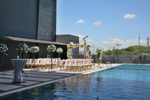 莎阿南格诺莎阿南酒店的一组桌子和椅子,位于游泳池旁