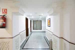 古尔冈Hotel Windsor Castle Cyber City的建筑的走廊,拥有白色的墙壁和天花板