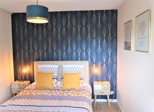 拉尼翁Appart'Confort - Le Trégor的一间卧室设有一张床和蓝色的墙壁