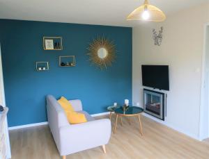 拉尼翁Appart'Confort - Le Trégor的带沙发和蓝色墙壁的客厅