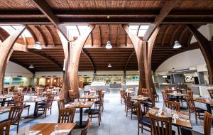 圣伊西多罗萨兰托村蓝色酒店的一间空餐厅,配有木桌和椅子