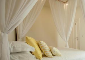 塞图巴尔Ana´s House的卧室配有白色窗帘和枕头。
