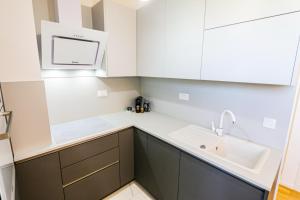 扎达尔Luce Gold Apartment的厨房配有白色橱柜和水槽