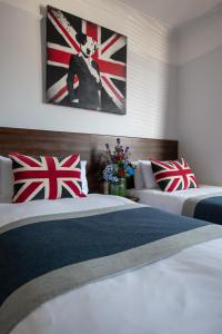 布莱顿霍夫新斯坦住宿加早餐酒店的两张床铺,位于酒店客房,墙上挂着英国国旗