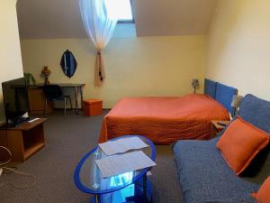 维尔纽斯Valentina's Rooms的酒店客房配有床、桌子和沙发。