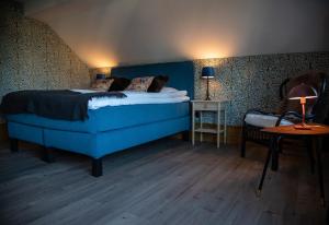 ForsvikVilla Göta的一间卧室配有蓝色的床和边桌