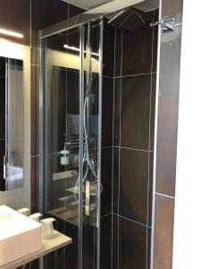 塔拉斯孔杜维亚都可酒店的浴室里设有玻璃门淋浴