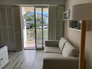 丰沙尔Apartamentos do Mar的带沙发和滑动玻璃门的客厅