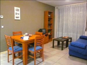 阿尔巴拉辛Apartamentos Los Mayos de Albarracín的客厅配有桌子和蓝色沙发