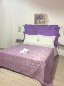 巴尼奥雷焦Casa Violet per Civita的紫色的床,上面有两条毛巾