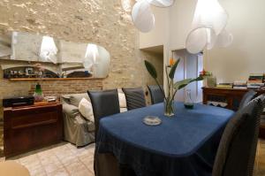 罗希姆诺Smaragdi Boutique Hotel的一间带蓝色桌子和沙发的用餐室