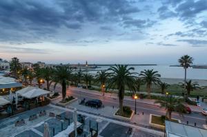 罗希姆诺Smaragdi Boutique Hotel的享有棕榈树和大海的城市美景。