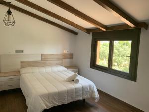 波索阿尔孔Casa Rural Las Nueces的一间卧室设有一张大床和一个窗户。