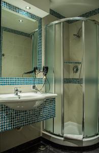 罗马卡诺瓦酒店的一间带水槽和玻璃淋浴的浴室