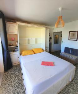 勒拉旺杜Appartement plein sud les Cyclades的卧室配有带橙色枕头的大型白色床