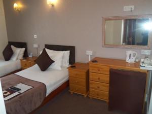 布莱克浦Novello Blackpool的酒店客房设有两张床、梳妆台和镜子。