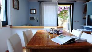 托里格兰德Welcomely - Sardinian Stone House的用餐室配有带酒杯的木桌