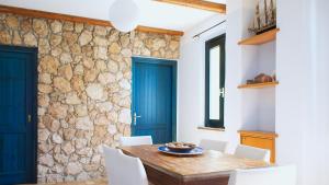 托里格兰德Welcomely - Sardinian Stone House的一间设有石墙和木桌及椅子的用餐室