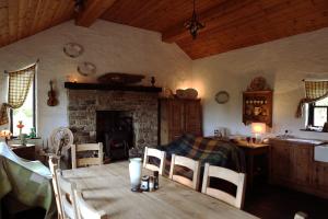 多尼戈尔The Spinner's Cottage的一间带桌子和壁炉的用餐室