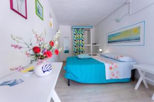 马蒂纳塔B&B Auliv的一间卧室配有一张床、一张桌子和鲜花