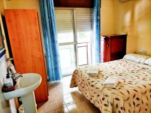 格拉纳达格拉纳达AB膳食公寓的一间卧室配有床、水槽和窗户
