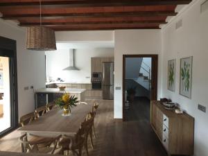波索阿尔孔Casa Rural Las Nueces的厨房以及带木桌和椅子的用餐室。