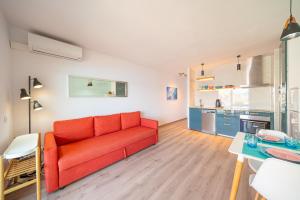 莱斯卡拉Apartment Sofia的一间带红色沙发的客厅和一间厨房