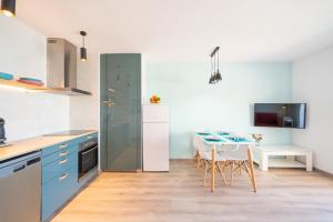 莱斯卡拉Apartment Sofia的厨房配有蓝色橱柜和桌椅