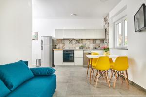 乌马格Apartmani Ivana的客厅配有蓝色的沙发和黄色的椅子
