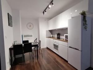 克拉科夫Green Apartments Kraków的厨房配有桌子和白色冰箱。