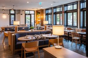 班夫麋鹿+大道酒店的餐厅设有桌椅和窗户。
