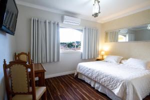 坎波斯杜若尔当内华达酒店的卧室配有白色的床和窗户。