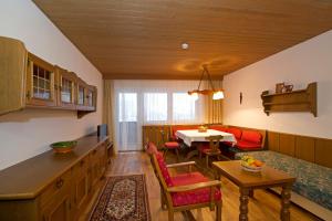 瓦尔赫湖蒂罗勒之家公寓的厨房以及带桌子和沙发的客厅。
