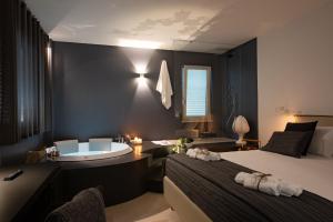 莫诺波利Suite1212 - Rattazzi的一间带浴缸的卧室和一间带两张床的卧室