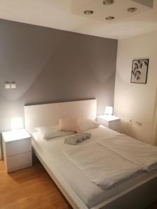 沙巴茨Veliki Park的一间卧室配有一张带2个床头柜的大型白色床